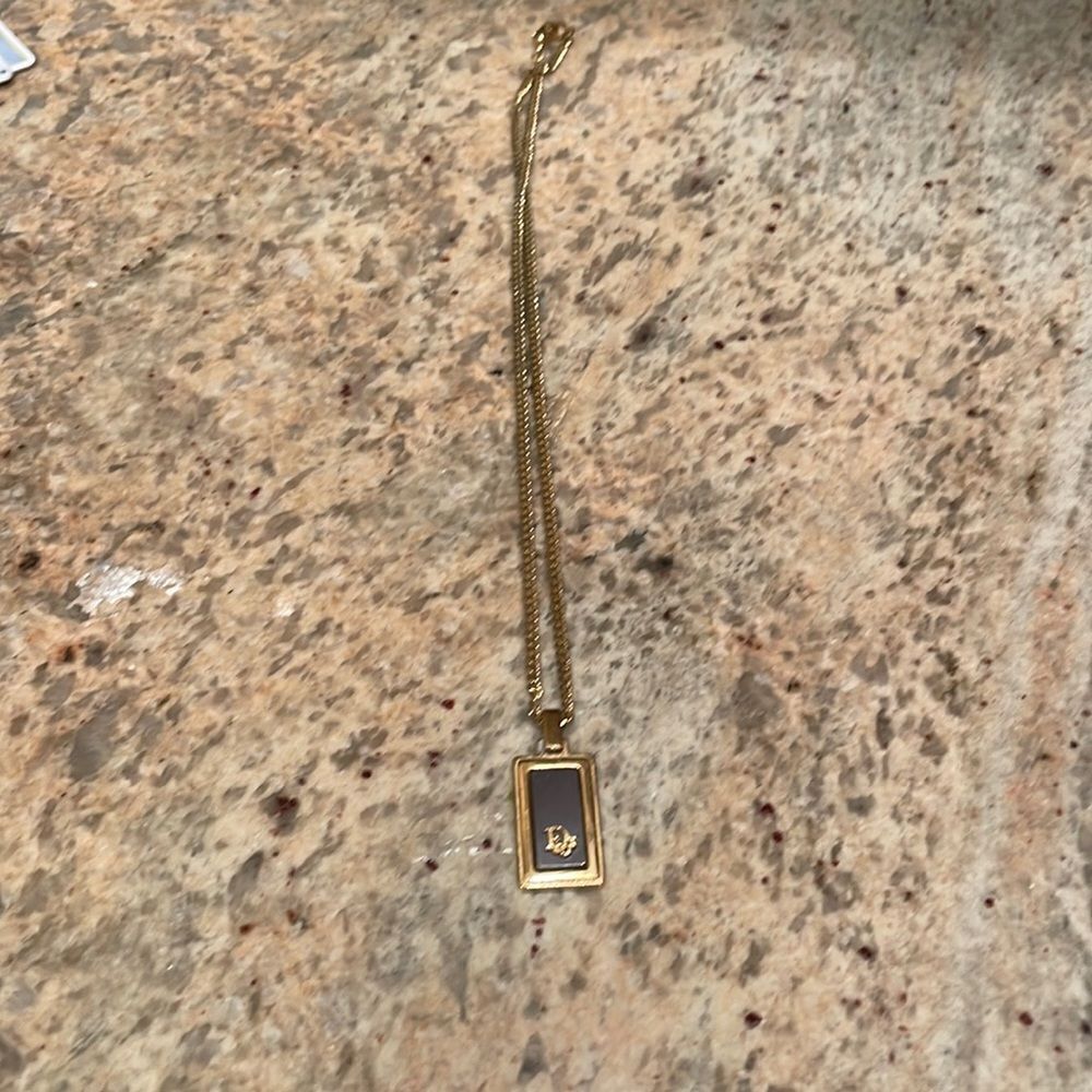Dior black and gold plated pendant necklace. It comes with a nice gold chain.